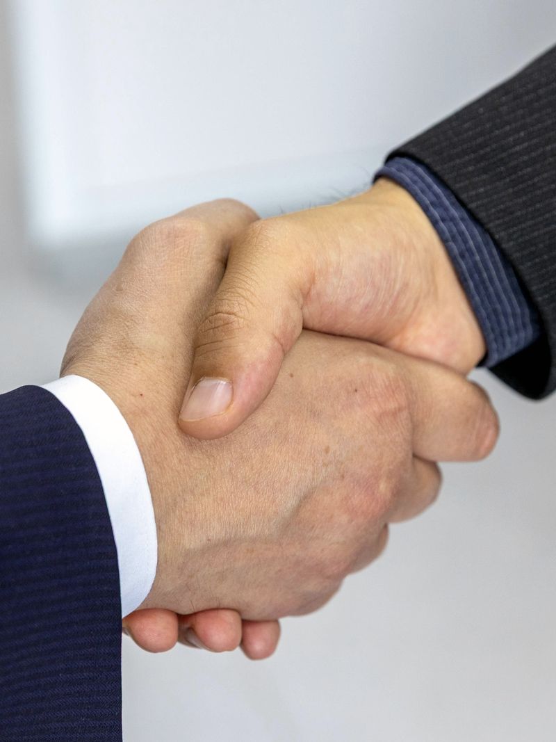 Firma de acuerdo y apretón de manos